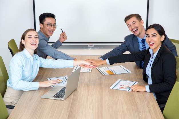 Free photo joyful business team joining hands together