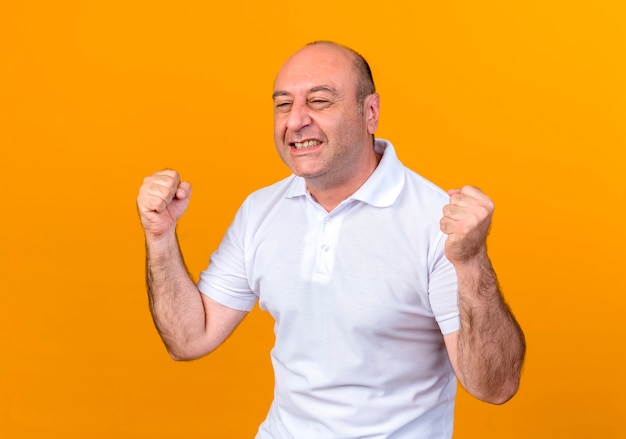 joyful casual mature man showing yes gesture isolated on yellow backgound