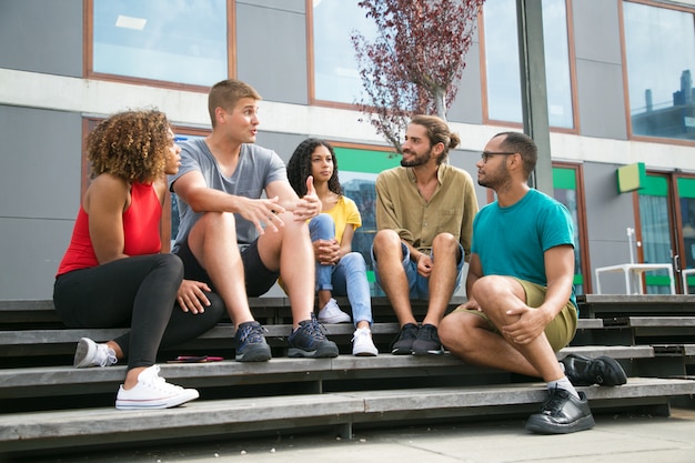 Free photo joyful caucasian guy telling exciting story to friends