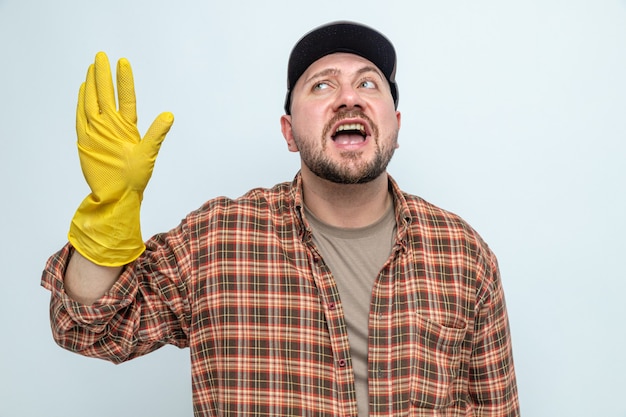 Joyful cleaner man with rubber gloves standing with raised hand 