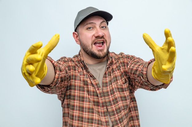 Joyful cleaner man with rubber gloves stretching out his hands