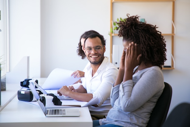 Joyful colleagues laughing during work