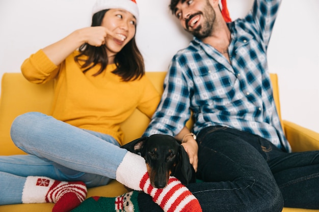 Joyful couple celebrating christmas on couch