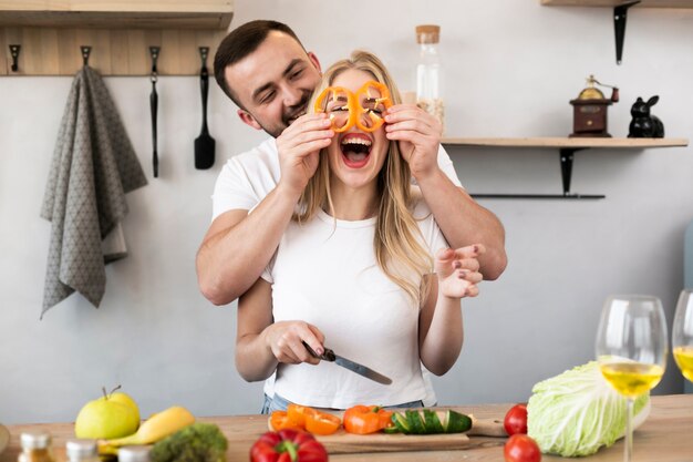 Joyful couple playing with bell pepper