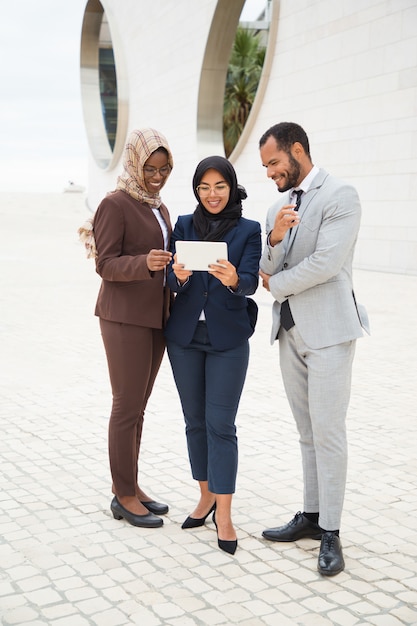 Joyful diverse business colleagues watching funny videos