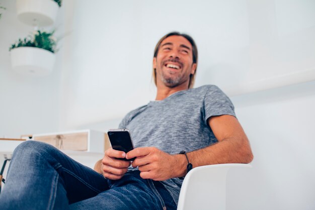 Free photo joyful entrepreneur laughing and using his mobile