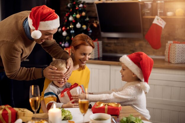 Joyful family having fun while exchanging Christmas presents at home