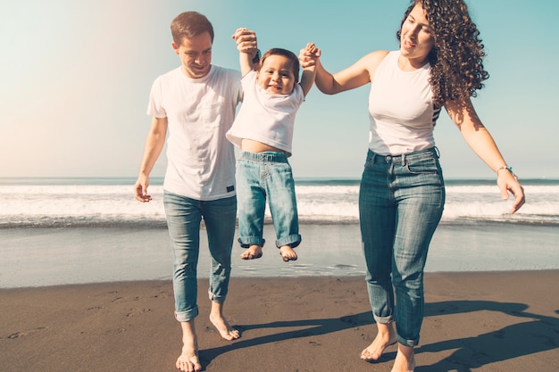 Foto gratuita famiglia gioiosa che gioca sulla costa