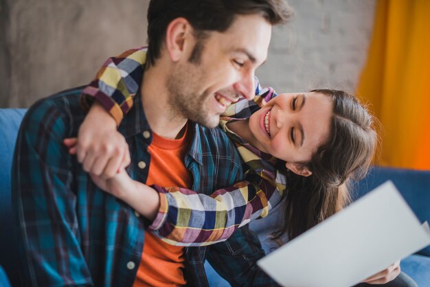 Joyful father and daughter looking at hand drawn card on fathers day