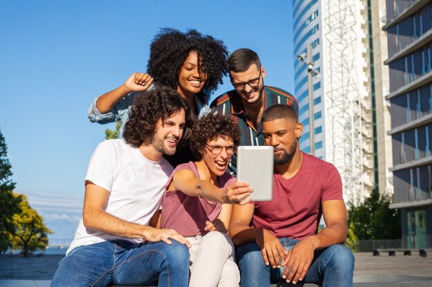 Joyful friends using tablet for group video call