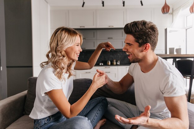 Joyful girl trying to distract her boyfriend while playing at home. Funny guy argue with his girlfriend during game.