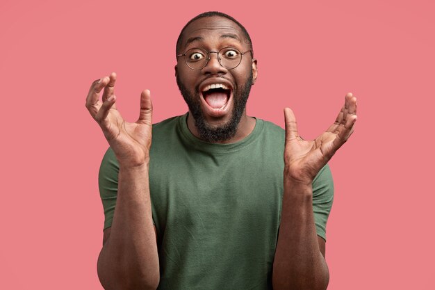 Joyful happy man father wants to tease his little child, gestures with hands, smiles positively