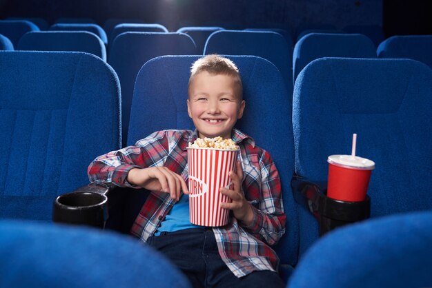 うれしそうな子供が笑って、映画館でコメディ映画を見て。