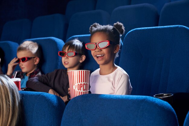 3 Dメガネで映画を見てうれしそうな子供たち。