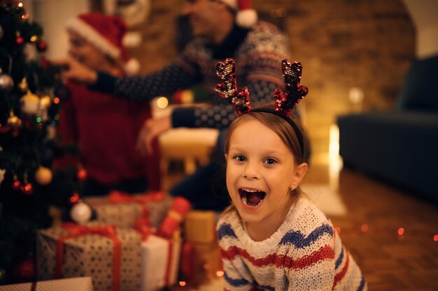 Joyful little girl having fun on Christmas eve at home