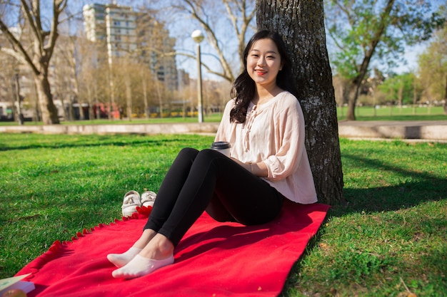 Радостная позитивная азиатская девушка наслаждается выходными на свежем воздухе