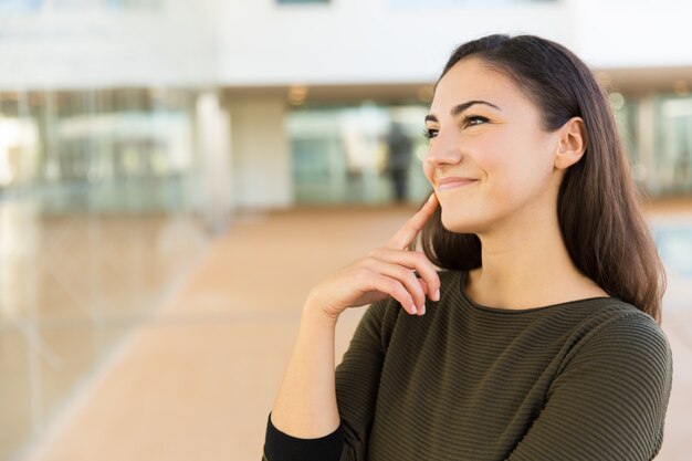 廊下に立っているうれしそうな肯定的な美しい女性