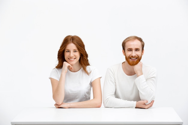 Joyful redhead, man and woman posing with hand on chin