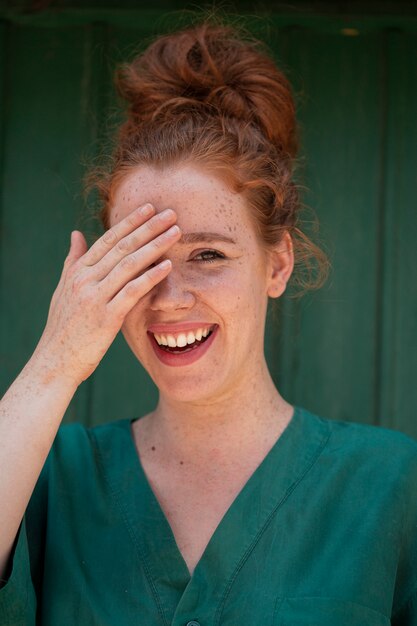 Joyful redhead woman covering one eye