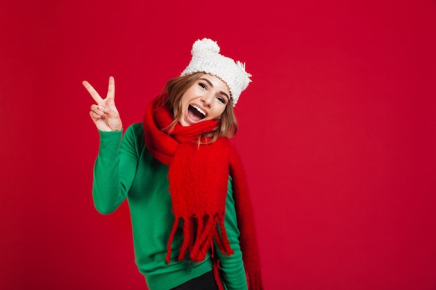 Foto gratuita donna castana urlando allegra in maglione, cappello divertente e sciarpa
