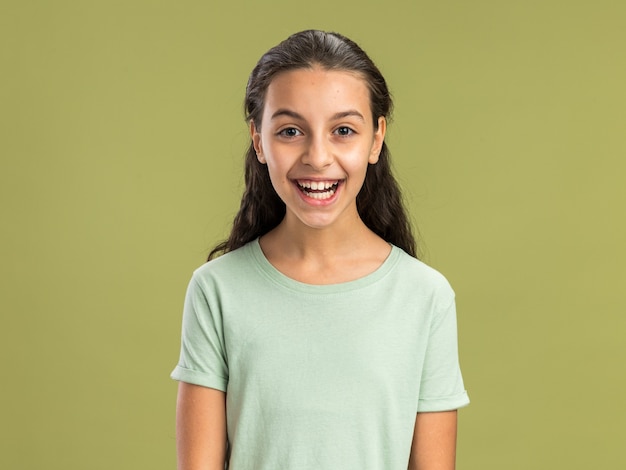 Free photo joyful teenage girl looking at front laughing isolated on olive green wall