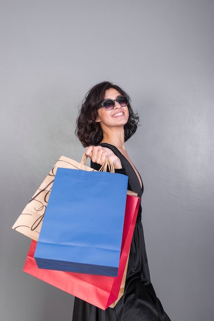 Joyful woman in black with gift boxes 