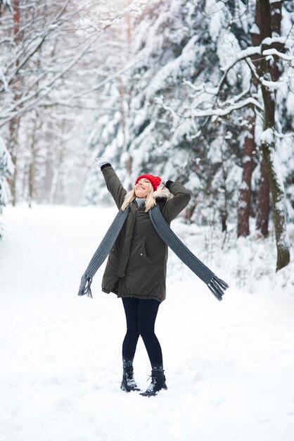 Joyful woman dancing in winter forest