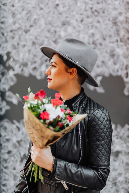 花の花束を持っているうれしそうな女性