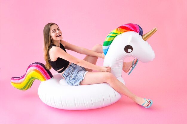 Joyful woman on inflatable unicorn