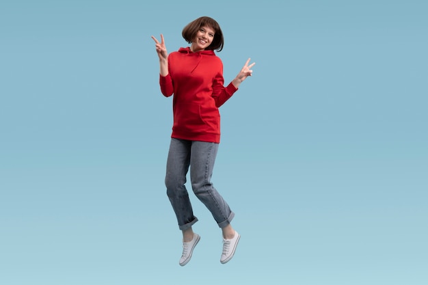 Joyful woman jumping isolated on blue