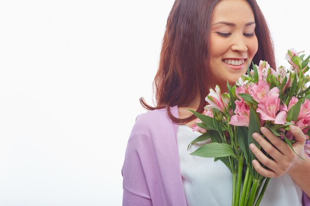 Joyful woman smelling her flowers