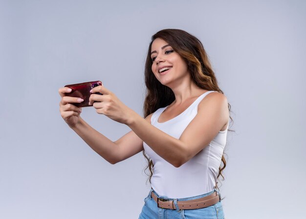 Joyful young beautiful girl using her phone 