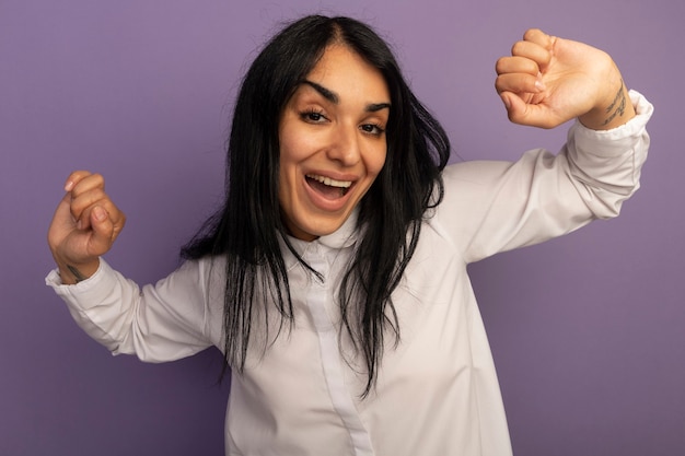 Free photo joyful young beautiful girl wearing white t-shirt dancing isolated on purple