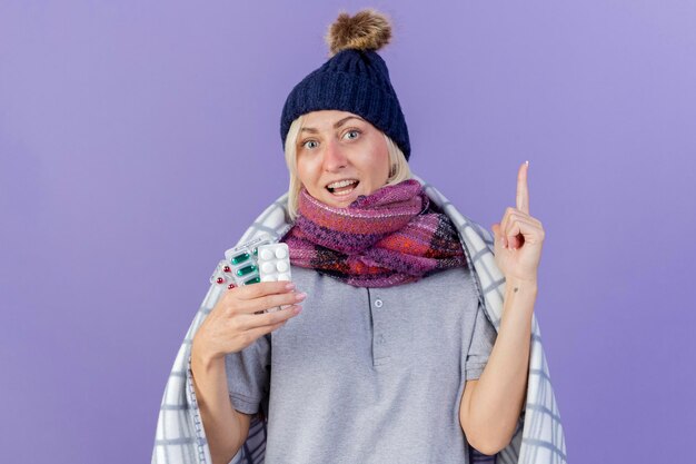 Joyful young blonde ill slavic woman wearing winter hat