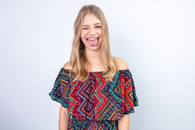 Радостная молодая славянская блондинка моргает и засунула язык