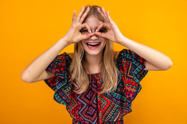 Joyful young blonde slavic girl through her fingers 