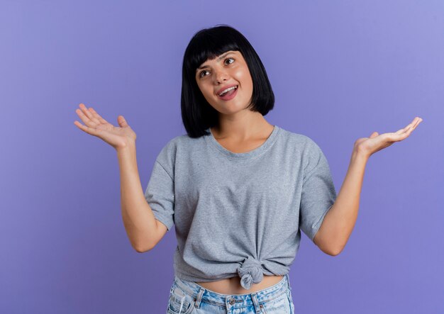 Joyful young brunette caucasian girl stands with raised hands looking at side 