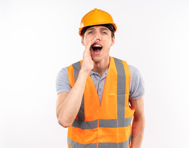 Joyful young builder man in uniform calling someone 