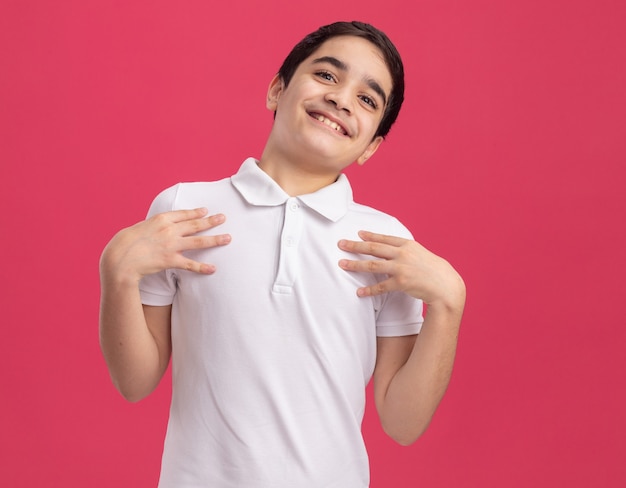 Joyful young caucasian boy touching chest 