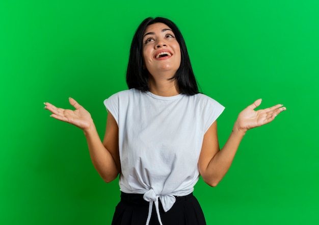 Joyful young caucasian girl stands with open hands looking up 