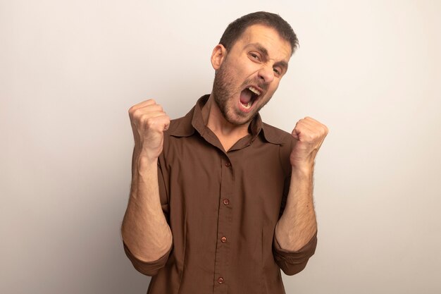 Joyful young caucasian man doing yes gesture looking at camera isolated on white background with copy space