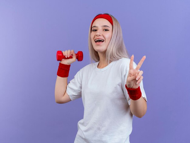 Joyful young caucasian sporty girl with braces wearing headband