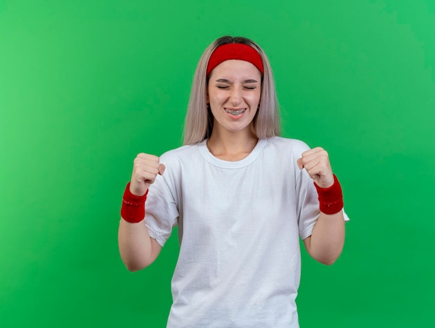 Бесплатное фото Радостная молодая кавказская спортивная девушка с подтяжками в головной повязке