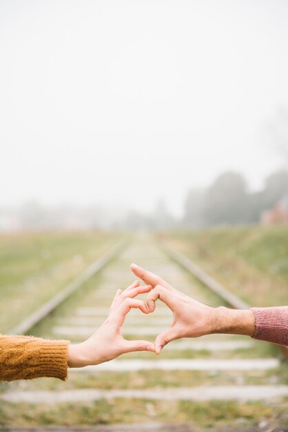 Joyful young couple showing heart sign