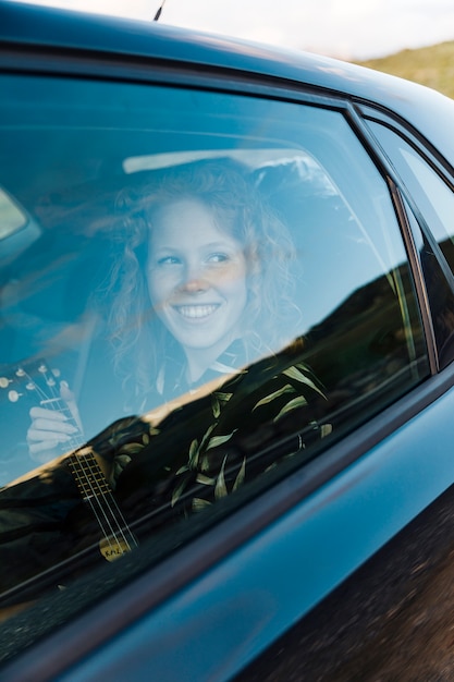 Joyful young female in car