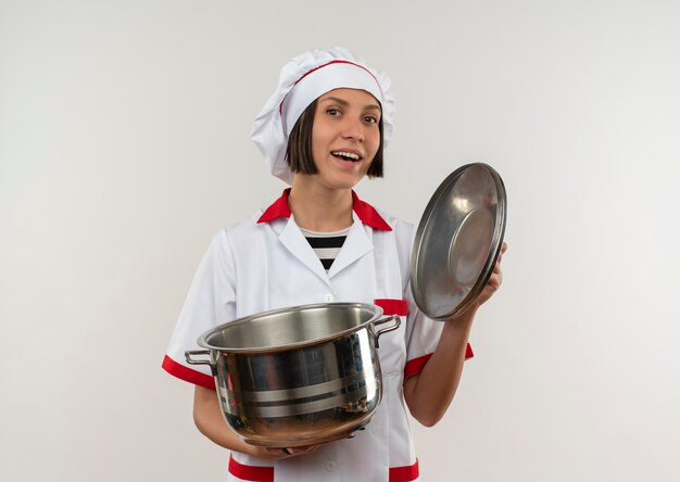 흰색에 고립 된 냄비와 냄비 뚜껑을 들고 요리사 유니폼에 즐거운 젊은 여성 요리사