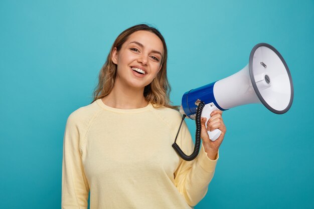 Joyful young girl holding speaker 