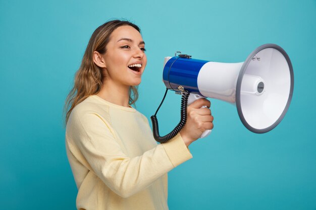 Joyful young girl standing in profile view looking at side talking by speaker 