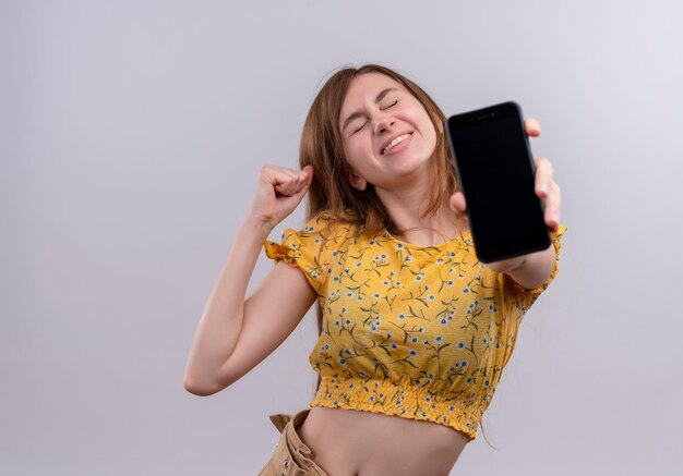 Joyful young girl stretching mobile phone   with copy space