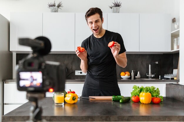 Joyful young man filming his video blog episode